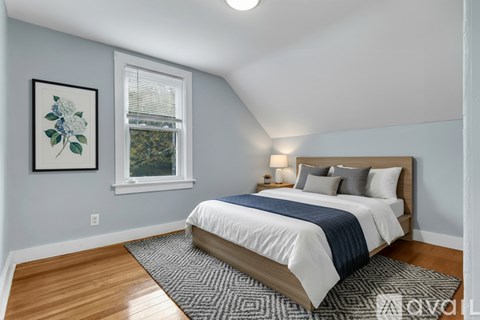 A bedroom with a large bed and a framed picture on the wall.