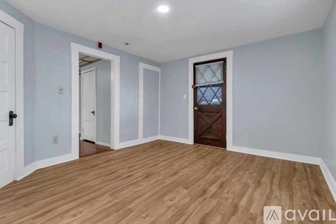 A room with wooden flooring and a white door.