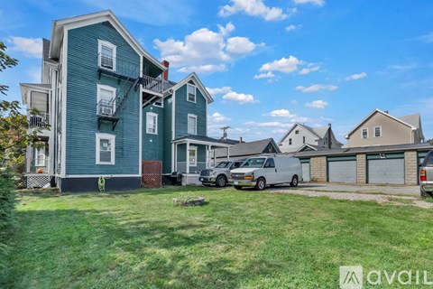 A blue two-story apartment building with a white van parked in front.