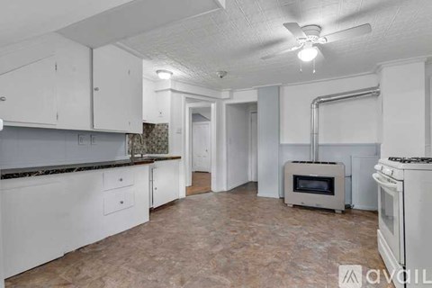 A kitchen with white cabinets and a marble countertop.