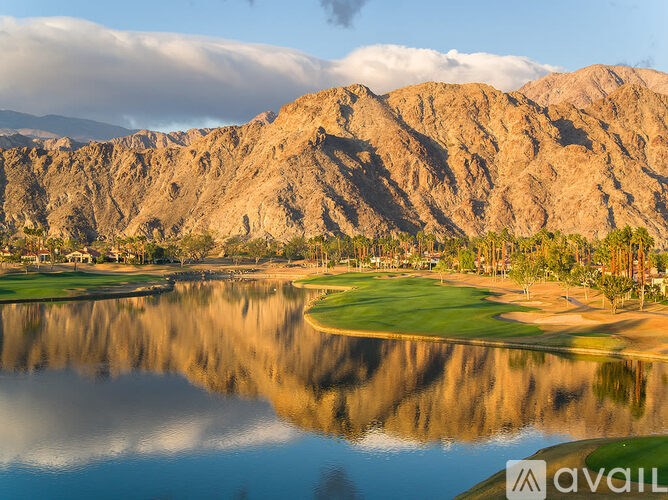A mountain range is reflected in a body of water.