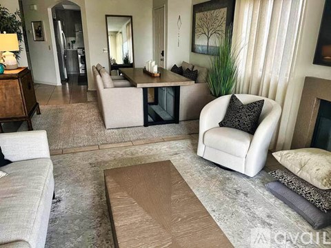 A living room with a white chair and a brown rug.