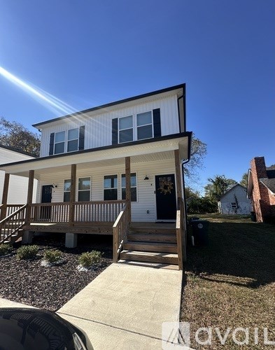 A two-story house with a white exterior and a black door.