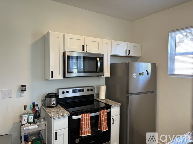 A kitchen with a black stove top oven and a silver refrigerator.