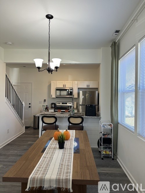 A dining room with a wooden table and chairs.