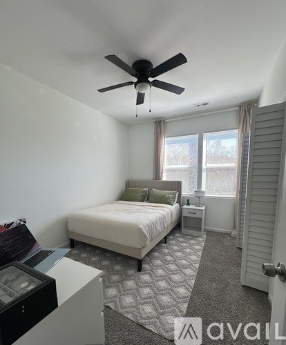 A bedroom with a bed, nightstand, and window.