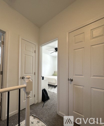 A hallway with white doors and a carpeted floor.