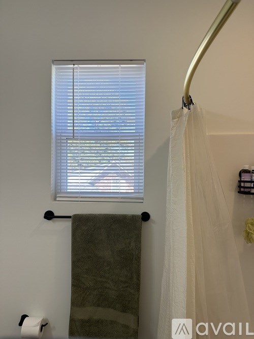 A bathroom with a toilet paper roll on the wall.