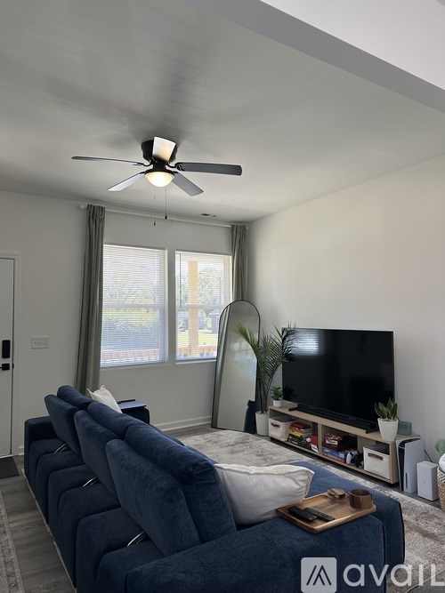 A living room with a blue couch and a television on a stand.