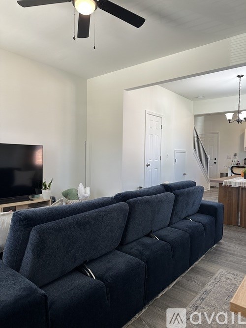 A living room with a dark blue couch and a television.