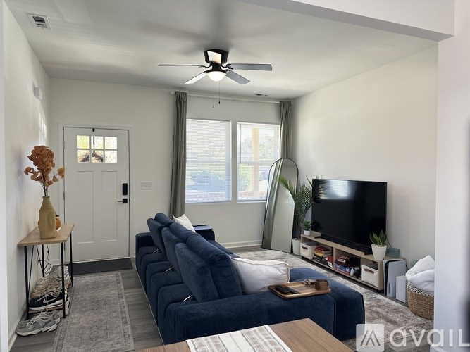 A living room with a blue couch and a flat screen TV.