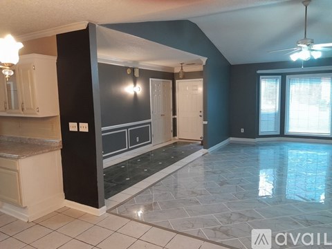A kitchen with a marble floor and white cabinets.