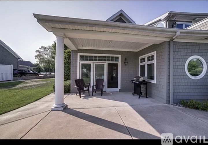 A house with a covered patio area has a white column supporting the roof.