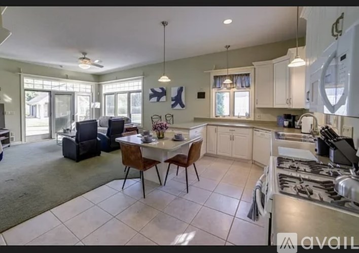 A kitchen with a dining table and chairs in the middle of the room.