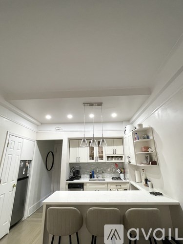 A kitchen with white cabinets and a white table with four chairs.