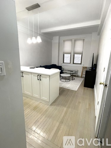 A kitchen with white cabinets and a black countertop.