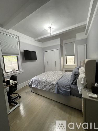 A bedroom with a bed, desk, and chair.