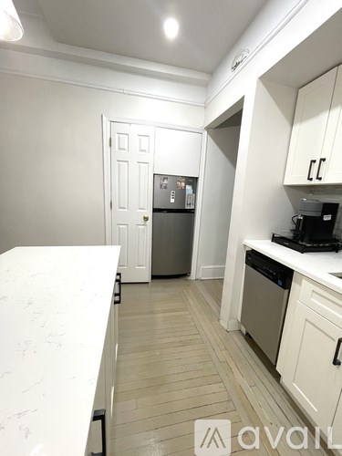 A kitchen with white cabinets and a white counter top.
