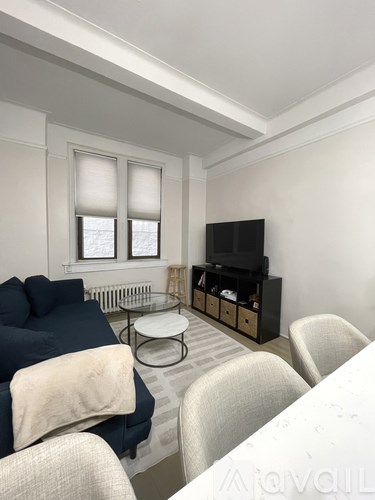 A living room with a blue sofa and a television.