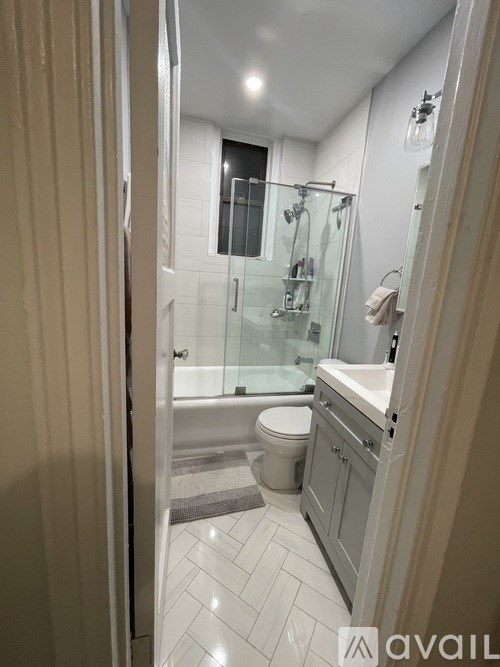 A bathroom with a toilet, sink, and shower.