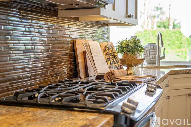 A kitchen with a stove top oven and a tile backsplash.