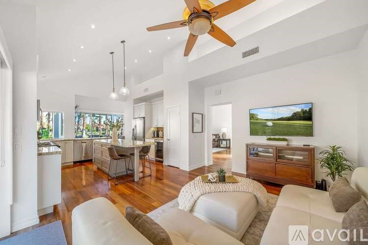 A living room with a white couch and a ceiling fan.