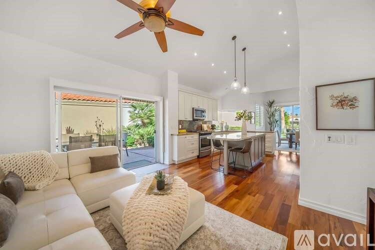A living room with a white couch and a ceiling fan.