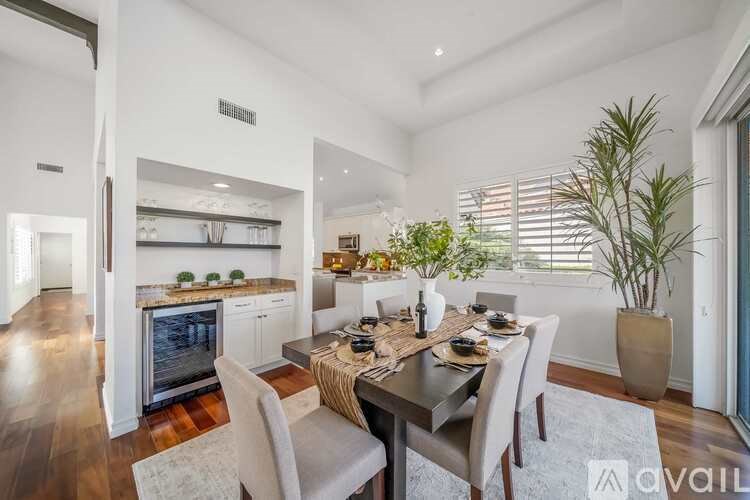 A modern dining room with a wooden table and chairs.