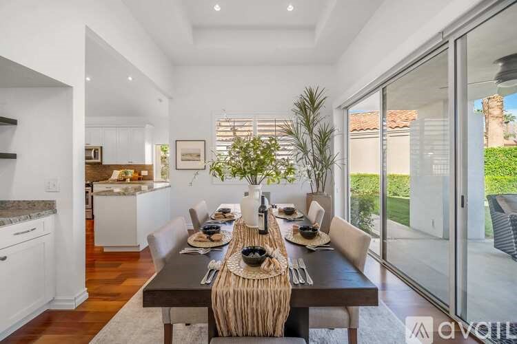 A modern dining room with a long table set for a meal.