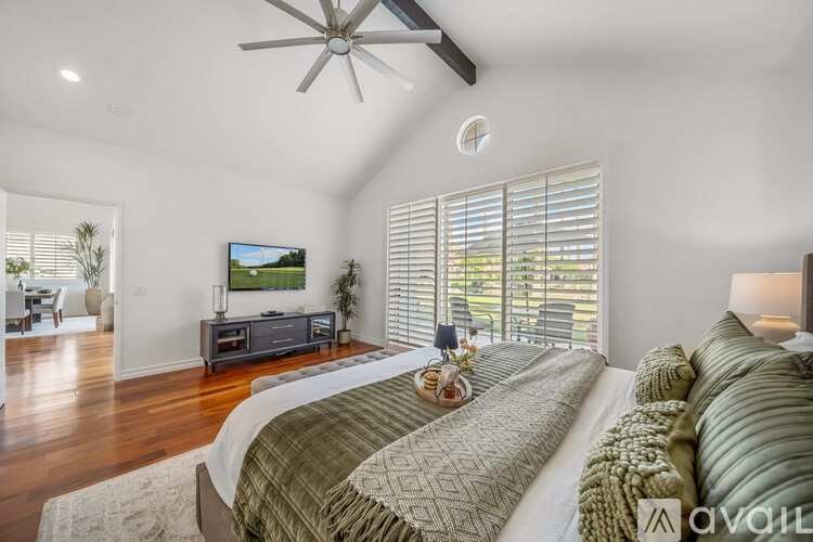 A bedroom with a large bed and a television in the corner.