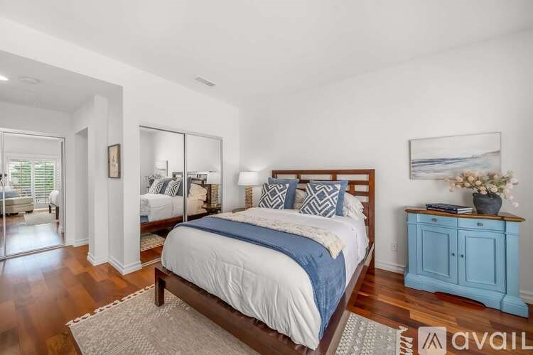 A bedroom with a large bed and a blue cabinet.