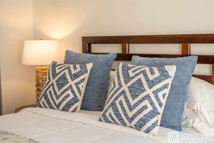 A bed with two blue and white patterned pillows.