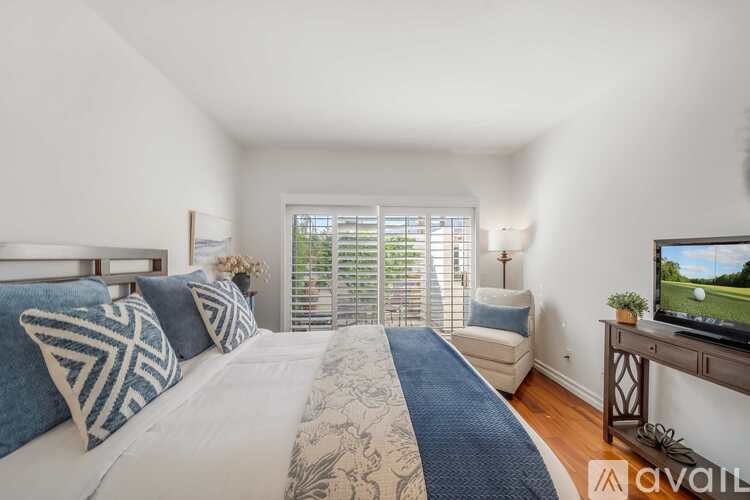 A bedroom with a large bed and a television on a stand.