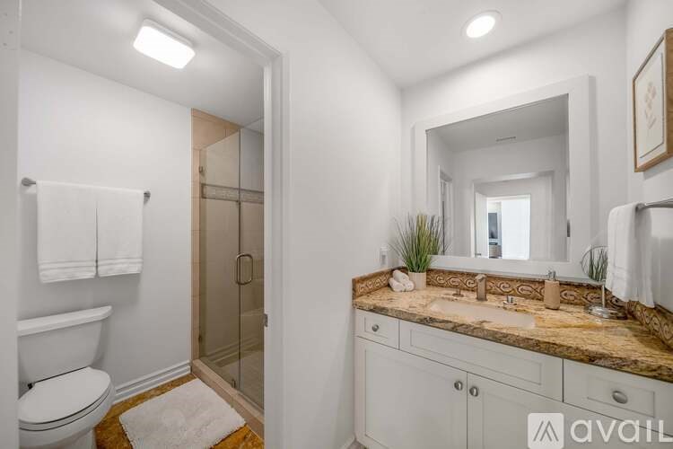 A bathroom with a toilet, sink, and mirror.