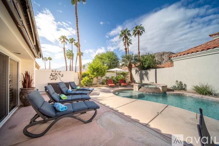 A sunny backyard with a pool and a chair.