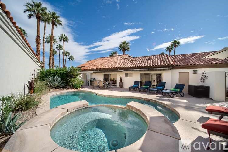 A pool with a hot tub in the middle of a backyard.