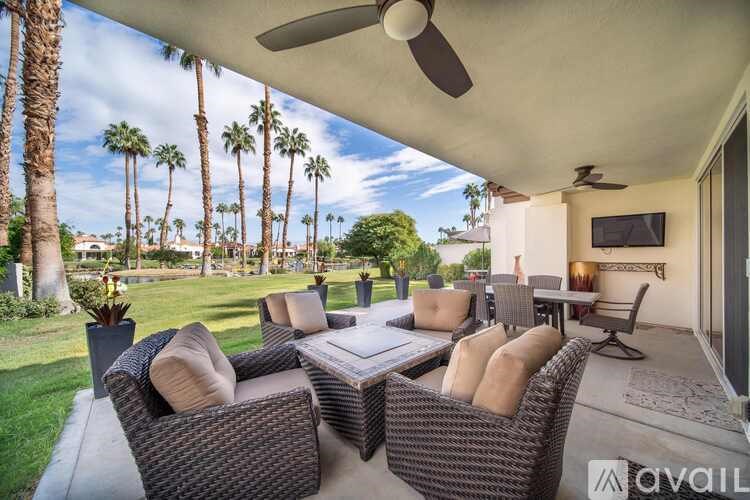 A patio with a table and chairs under a roof.