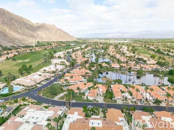 A bird's eye view of a residential area with a winding road.