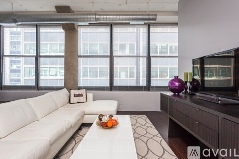 A living room with a white couch and a television.
