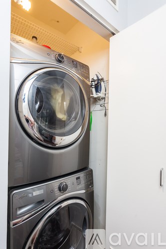 A stack of two front loading washing machines in a small laundry room.