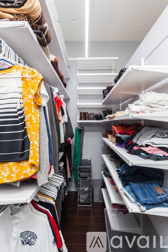 A white shelf with clothes on it.