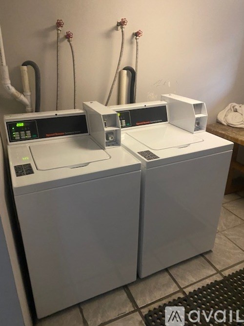 Two identical washing machines are sitting next to each other.
