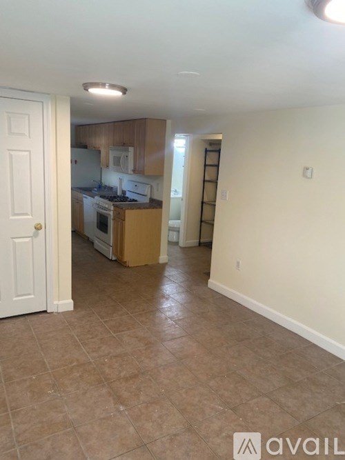 A kitchen area with a white door and a tiled floor.