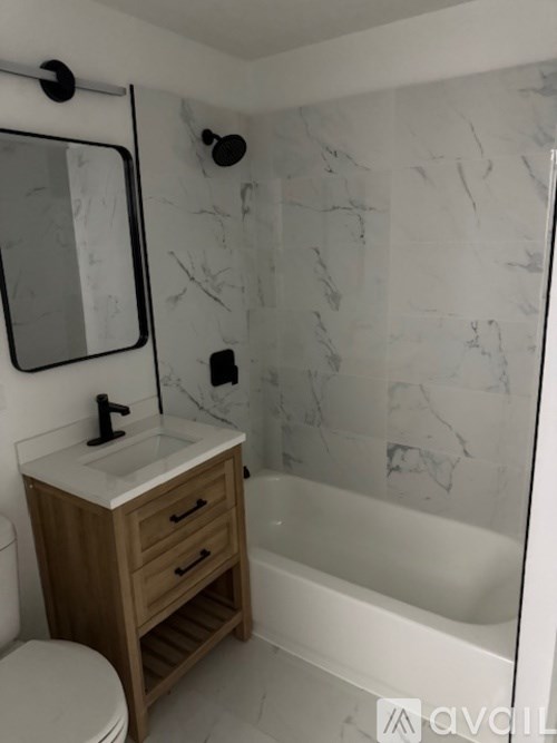 A bathroom with a marble wall and a wooden vanity.