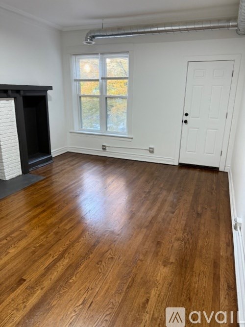 A room with wooden flooring and a white door.