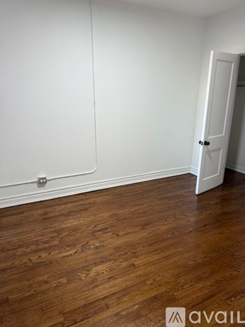 A room with wooden flooring and a white door.