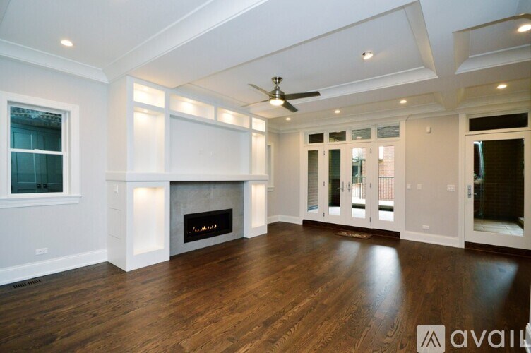 A spacious living room with a fireplace and a ceiling fan.