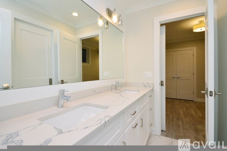 A bathroom with a marble countertop and a large mirror.