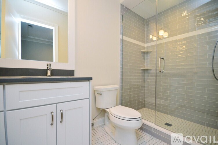 A bathroom with a toilet, a sink, and a shower.