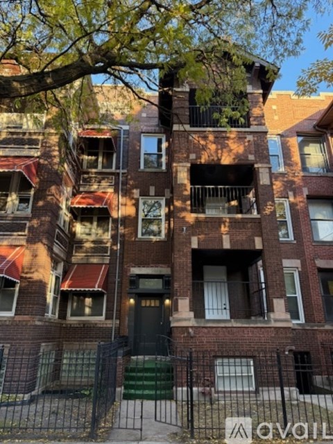A tall brick building with a black gate in front.